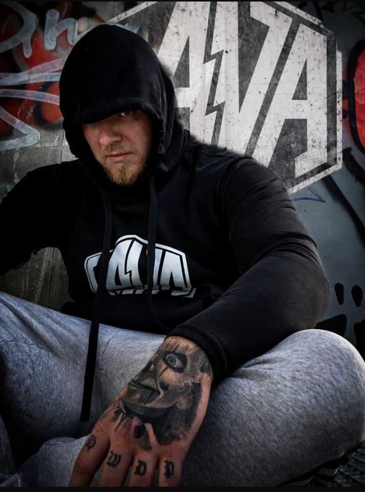 Mann im schwarzen LAVA Hoodie vor einer LAVA Graffiti-Wand
