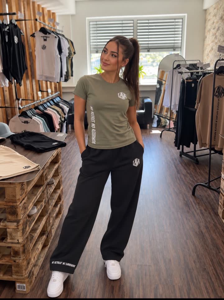 Frau in olivgrünem LAVA T-Shirt und schwarzer Jogginghose im LAVA Store